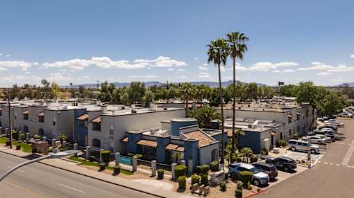 an aerial view of a row of apartment buildings and palm trees