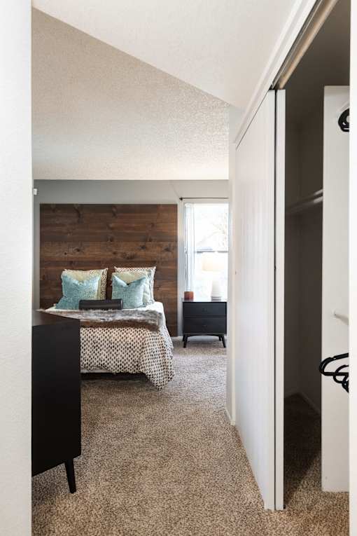 a bedroom with a bed and a wooden accent wall