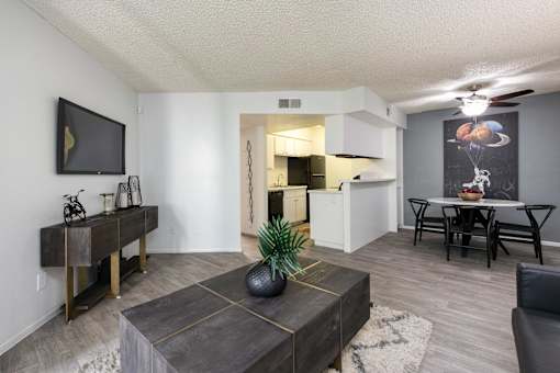 a living room with a couch and a table and a kitchen