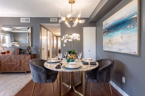 A dining room with a round table set for four.