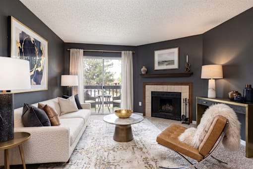 A living room with a fireplace and a chair with a fur throw.