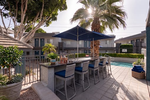 A patio with a table and chairs under a blue canopy.