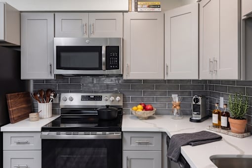 A modern kitchen with a stove, microwave, and oven.