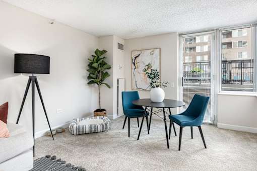 a living room with a table and chairs and a window