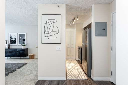an open living room and kitchen with a refrigerator and a sink