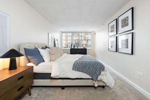 a bedroom with a bed and a dresser and a window