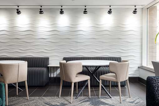 a table and chairs in a room with a white wall