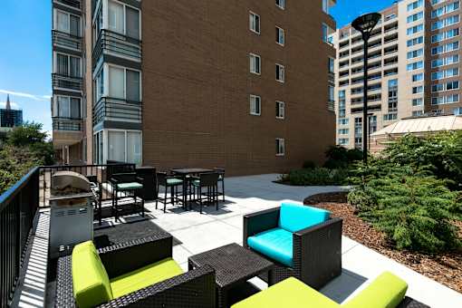 a patio with chairs and tables in front of a building