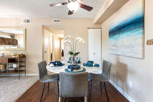 a dining room with a table and chairs and a ceiling fan