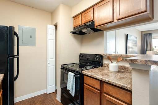 an updated kitchen with black appliances and granite counter tops