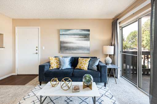 a living room with a couch and a coffee table and a sliding glass door