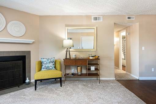 a living room with a fireplace and a yellow chair