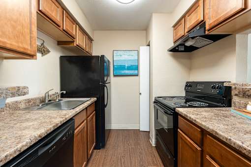 a kitchen with granite counter tops and black appliances