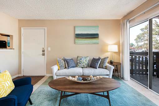 a living room with a couch and a coffee table and a balcony