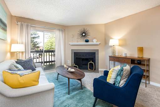a living room with a couch and a chair and a fireplace