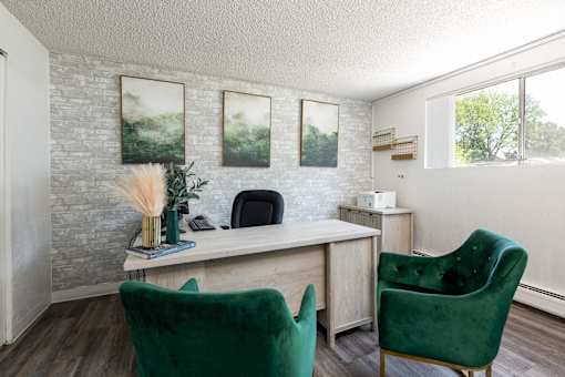an office with green chairs and a desk and a window