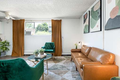 a living room with brown leather furniture and green chairs