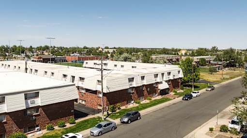 an aerial view of a building with cars parked on the street