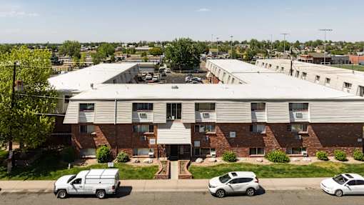 an aerial view of a building with cars parked in front
