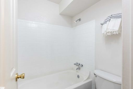 a white bathroom with a tub and a toilet