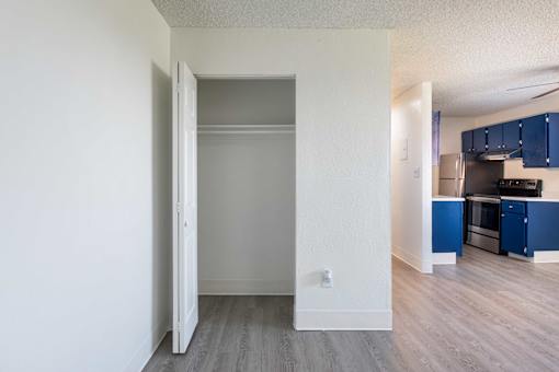 Living room and kitchen with navy cabinets and wood floor