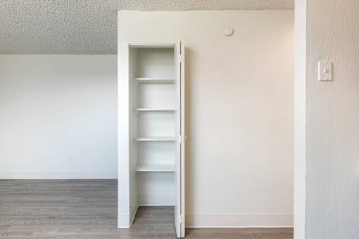 an empty closet in a room with white walls and wood floors