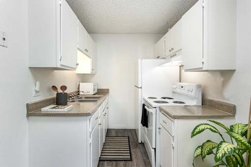 a kitchen with white appliances and counters and white cabinets