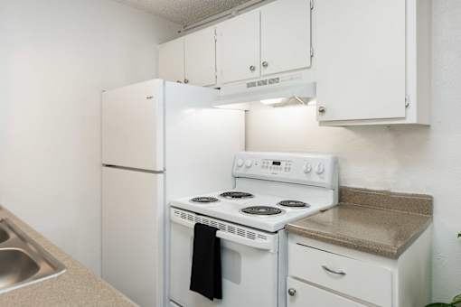 a kitchen with white appliances and white cabinets and a white refrigerator