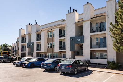 an apartment building with cars parked in front of it