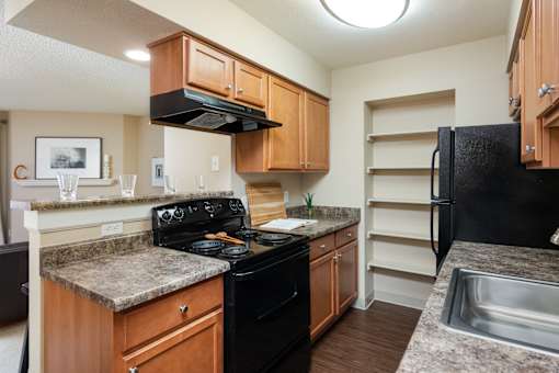 an updated kitchen with granite counter tops and black appliances