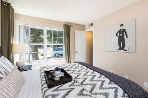 a bedroom with a bed and a picture of a man on the wall