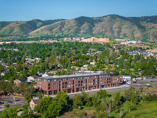 A large red building sits in the middle of a green field.