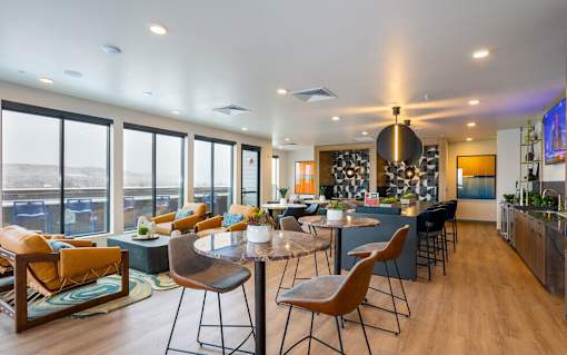 A modern living room with a kitchen area in the background.