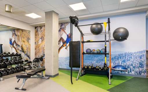 A gym with a wall mural of a climber and a green floor.