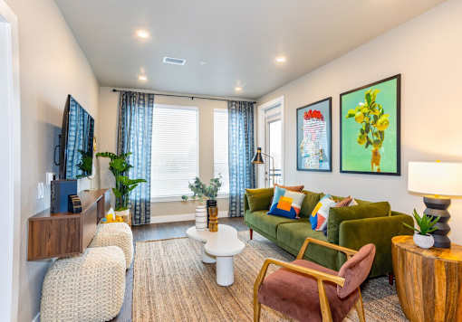 A living room with a green couch, a white coffee table, and a painting on the wall.