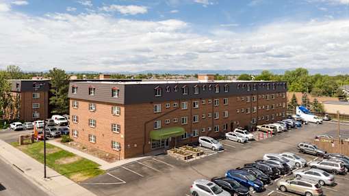 an aerial view of a building with a parking lot full of cars