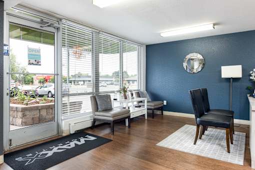 a living room with blue walls and a window with chairs and a table