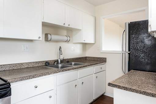 a kitchen with white cabinets and a sink and a refrigerator