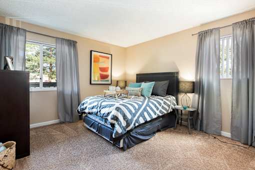 a bedroom with a bed and two windows