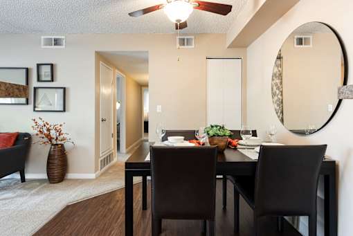 a dining room with a table and chairs and a mirror