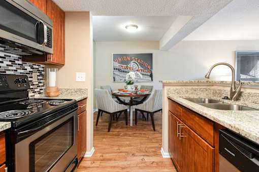 the kitchen and dining area of a home with a table and chairs