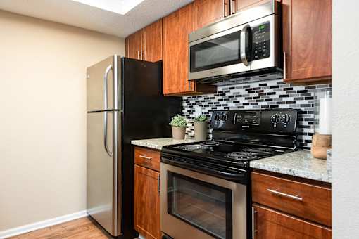 a kitchen with black appliances and a stainless steel refrigerator