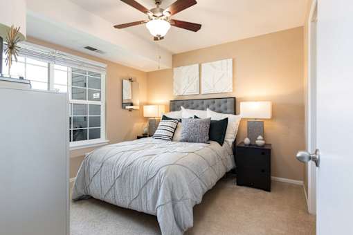 a bedroom with a large bed and a ceiling fan