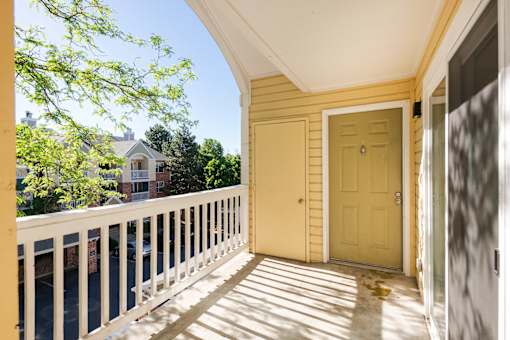 the front porch of a yellow house with a yellow door