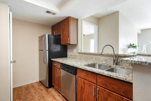 an empty kitchen with a stainless steel refrigerator and sink
