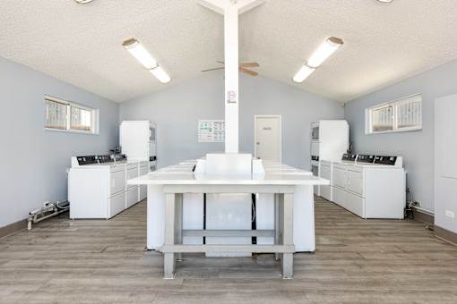 a kitchen with white appliances and a white table