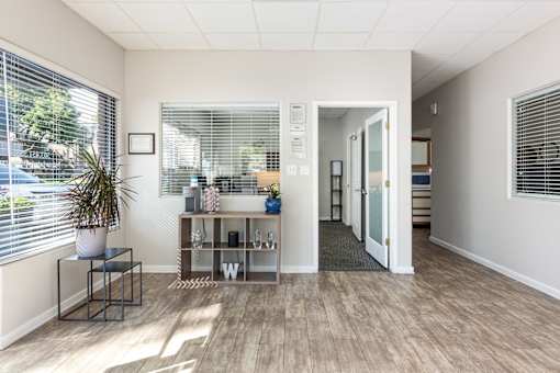 an office with a large window and a hallway with a table