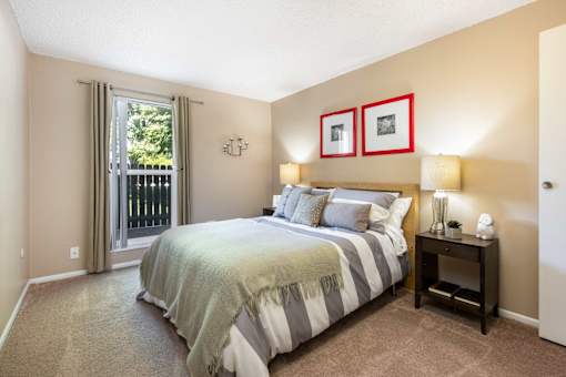 a bedroom with a bed and a door to a balcony