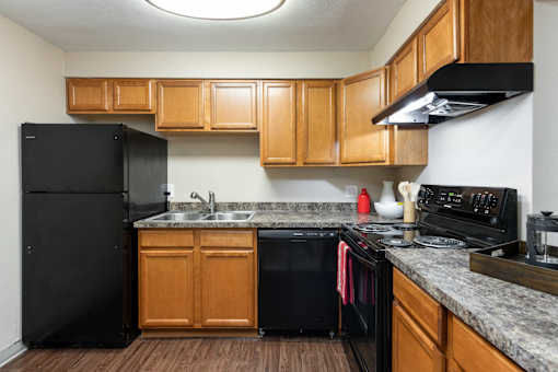 a kitchen with black appliances and wooden cabinets