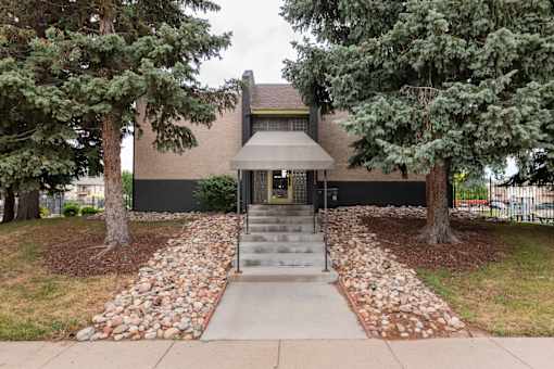 the front of a house with trees and a sidewalk